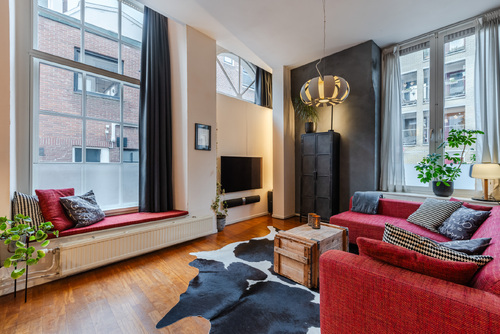 De ruime woonkamer met open keuken heeft veel lichtinval en een prachtig uitzicht op het water.