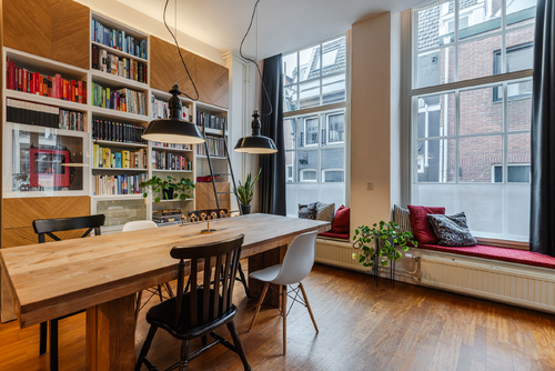 De ruime woonkamer met open keuken heeft veel lichtinval en een prachtig uitzicht op het water.