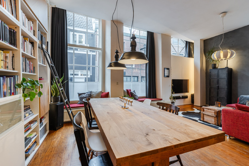 De ruime woonkamer met open keuken heeft veel lichtinval en een prachtig uitzicht op het water.