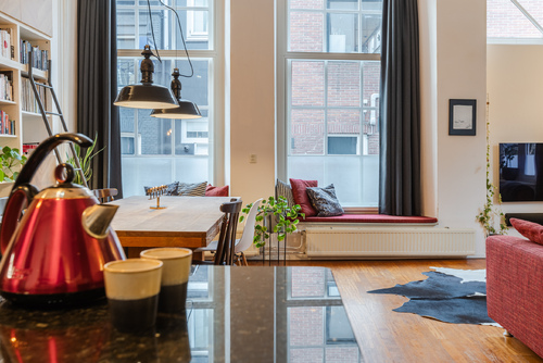 De ruime woonkamer met open keuken heeft veel lichtinval en een prachtig uitzicht op het water.