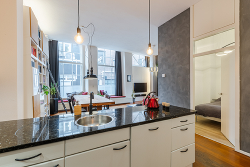 De ruime woonkamer met open keuken heeft veel lichtinval en een prachtig uitzicht op het water.