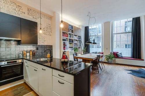 De ruime woonkamer met open keuken heeft veel lichtinval en een prachtig uitzicht op het water.