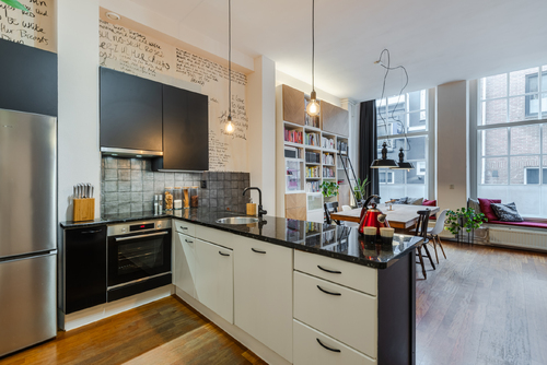 De ruime woonkamer met open keuken heeft veel lichtinval en een prachtig uitzicht op het water.